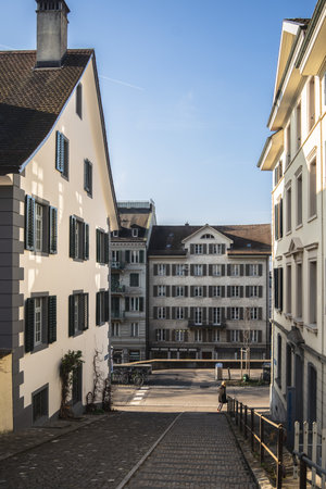 A sloped street between buildings under a clear blue skyのeditorial素材