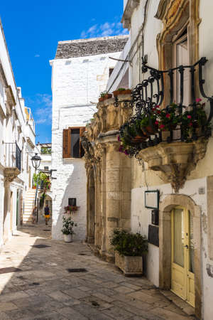 A vertical shot of the outside of beautiful white historic buildings in Locorotondo, Apulia, Italyのeditorial素材
