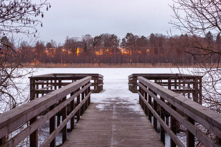 A beautiful shot of wooden pathway on the riverbank and burning forest on the opposite coastの写真素材