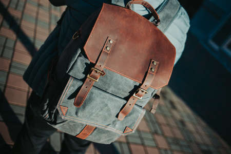 A shallow focus shot of a male wearing a grey and brown rucksack
