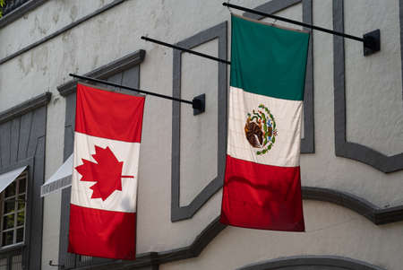 A closeup shot of Canada and Mexico flags attached to a wallの写真素材
