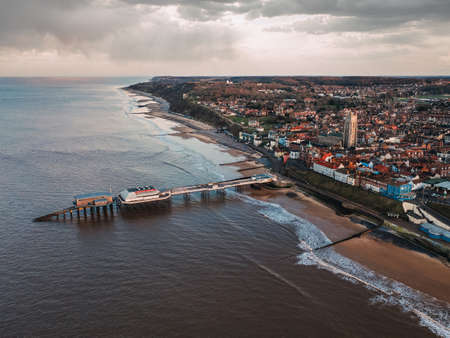 A bird-eye shot of the city, the public beach and the pier on a gloomy day