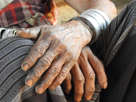 A closeup of the hands of a longneck woman in Myanmarの写真素材