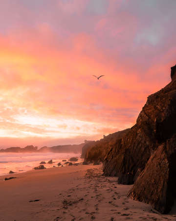 A vertical shot of the mountains on the beach during sunset