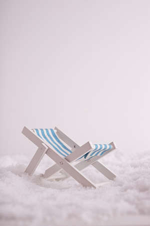 A closeup of a tiny toy sunbed in the snowの写真素材