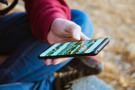 A selective focus shot of a male hand using his phoneの写真素材