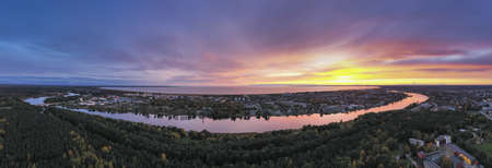 Aerial panoramic view to the Parnu city stretched out between the waters of the Parnu river and Bay in Estonia, colored by the beautiful sunsetの写真素材