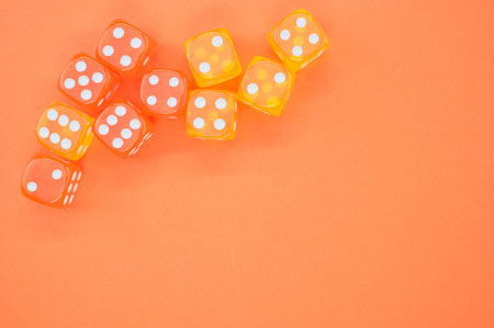 A high angle shot of dices on an orange surfaceの写真素材