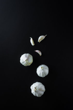 A vertical shot of garlic on black background