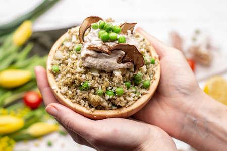 A closeup of a person holding a bowl of delicious vegan saladの写真素材