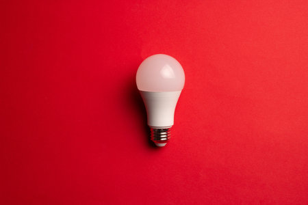 A top view of an electric light bulb on a red backgroundの写真素材