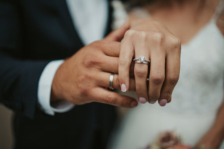 A beautiful shot of the hands of a bride and groom showing their rings - wedding, anniversaryの写真素材