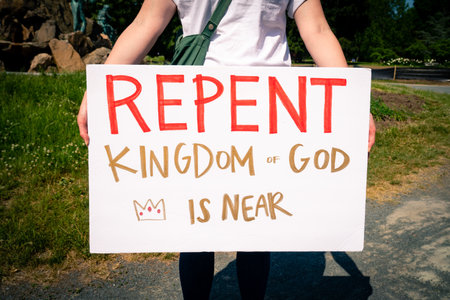 ALBANY, NEW YORK, UNITED STATES - Jun 09, 2020: A Christian calls on the public to repent for their signs because they believe the second coming of Jesus is imminent in a park in Albany, New Yorkの写真素材