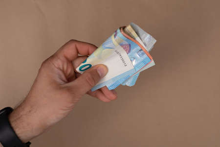 A closeup shot of a person's hand holding euro bills - money finance capital concept