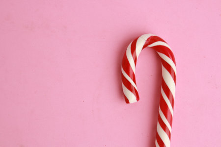 A high angle shot of a delicious candy stick isolated on a pink surfaceの写真素材