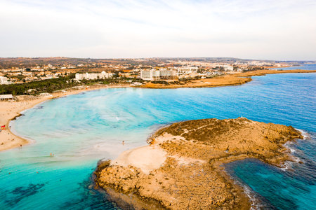 An aerial shot of Nissi beach in Ayia Napa, a famous tourist beach in Cyprus, with a blue clean waterの写真素材
