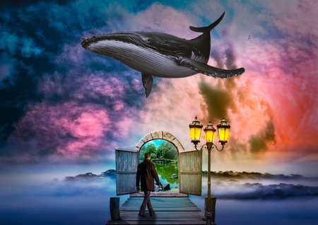 A male walking through a door to another dimension with a whale flying in the skyの写真素材