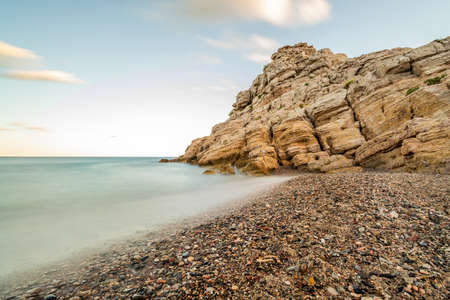 Rocky crag in the sea with blurred waterの写真素材