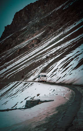 A vertical shot of a caravan traveling in the snow-covered mountains of Spiti valleyの写真素材