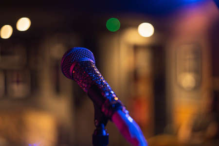 A closeup shot of a microphone on a blurred background with bokeh lightsの写真素材