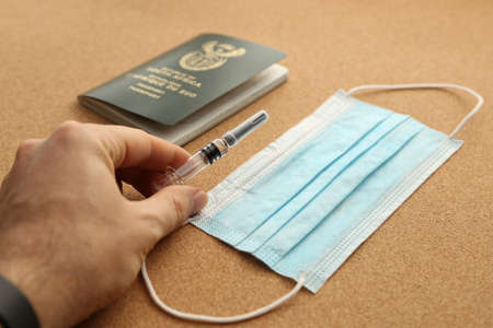 A high angle shot of a medical mask, vaccine and a passport - new normal conceptの写真素材