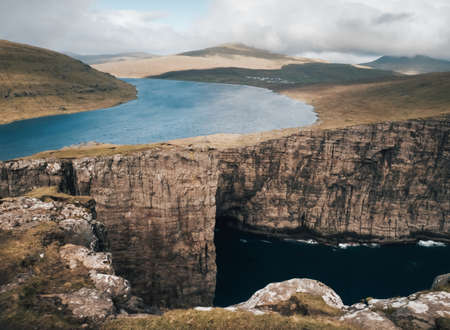 A shot capturing the beautiful nature of the Faroe Islands, lake, mountains, cliffsの写真素材