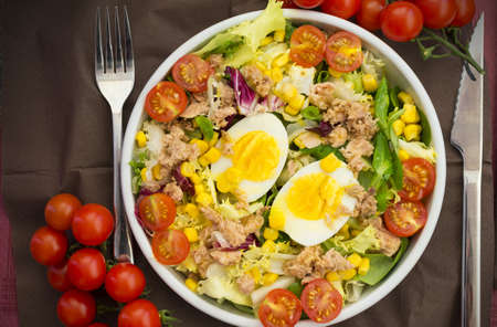 A bowl of mixed salad with boiled eggs, nuggets, tomatoes and cornの写真素材