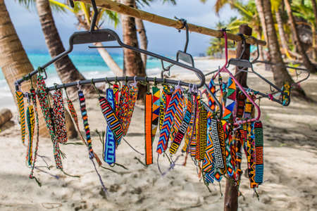 A view of colorful beads handmade bracelet in a hanger on a beachの写真素材