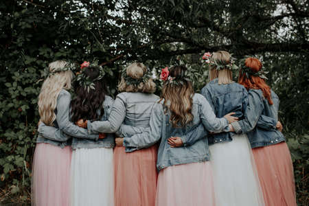 The young girls in beautiful dresses and denim jackets in the parkの写真素材