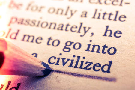 A closeup view of a page from a book, with a pencil underlining the word "civilized"の写真素材