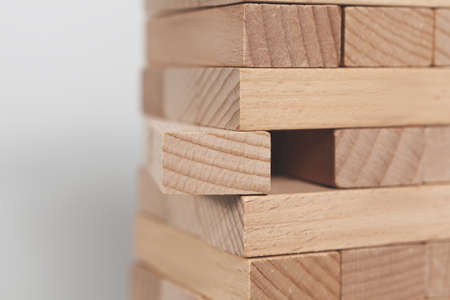 A selective focus shot of a wooden block tower isolated on a white background