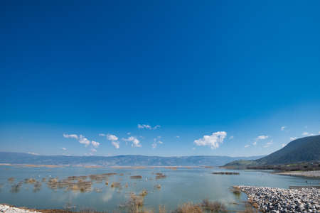 A majestic cloudscape over a calm Karla lake in Greece during the daytime