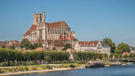 A beautiful shot of the Auxerre Cathedral near the Yonne river on a sunny afternoon in Franceの写真素材