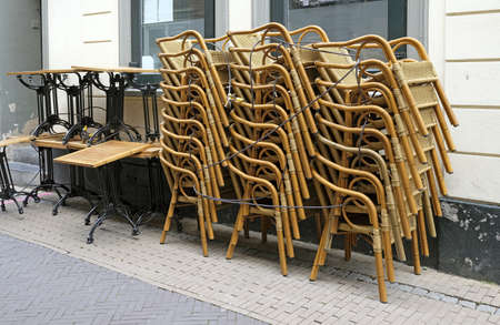 A closeup shot of stacked chairs and tables in front of a restaurant during the pandemic lockdownの写真素材