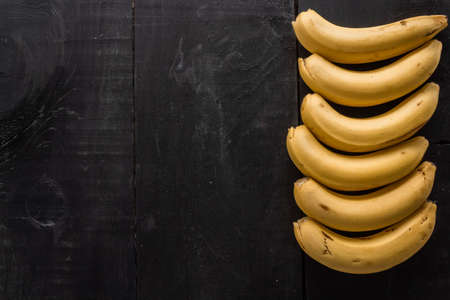 A high angle shot of bananas with a copy space on a black backgroundの写真素材