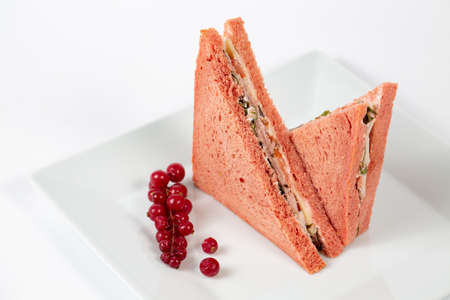 A tasty sandwich with pink bread on a white plateの写真素材