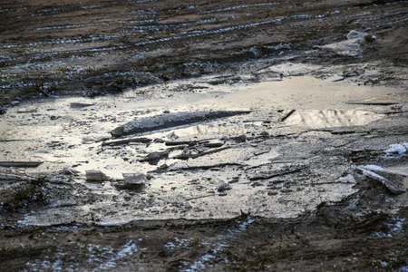 A wet mud puddle in a field after a rain