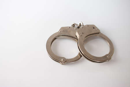A high angle shot of metal handcuffs isolated on a white background