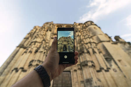 A man taking a photo of St. Mary Parish Church in Arcos de la Fronteraの写真素材