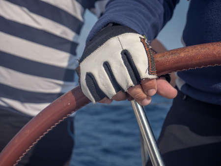 A soft focus of a man's hand on a bota's steering wheelの写真素材