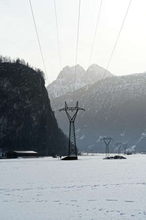 A vertical shot of the snow-covered mountains in the winter on a foggy dayの写真素材