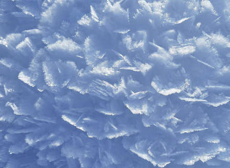 A closeup shot of snow crystals with a light blue background