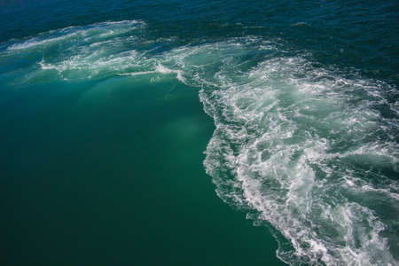 An aerial shot of a see wave with pure turquoise water during daytime