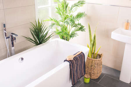 The beautifully decorated bathroom with a bathtub and a  faucet with a ceramic sink