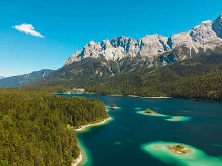 Amazingly beautiful aerial view of the Eibsee in Germany. Teal mountain lake and famous tourist destination at the foot of the Zugspitze in the alpsの写真素材