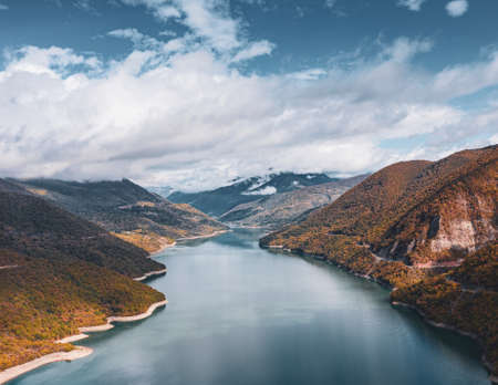 A high angle shot of a river going through the hills under the breathtaking cloudy skyの写真素材