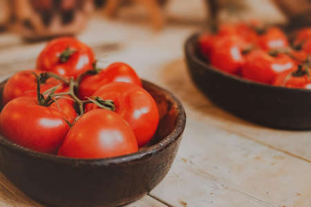 A closeup shot of a bunch of tomatoes in a black bowlの写真素材
