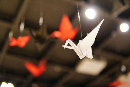 A low angle closeup shot of origami made colorful paper bird flying overの写真素材