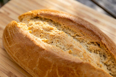 A closeup shot of delicious sourdough bread on a wooden surface under sunlight