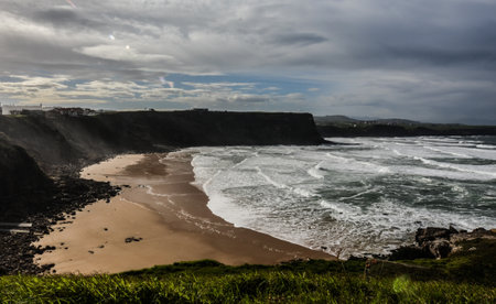 A high angle shot of a rocky beach surrounded by cliffs under a cloudy skyの写真素材